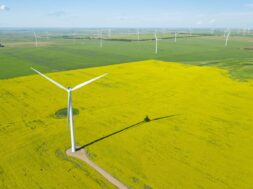 Aerial shot of wind generator in a large field during daytime